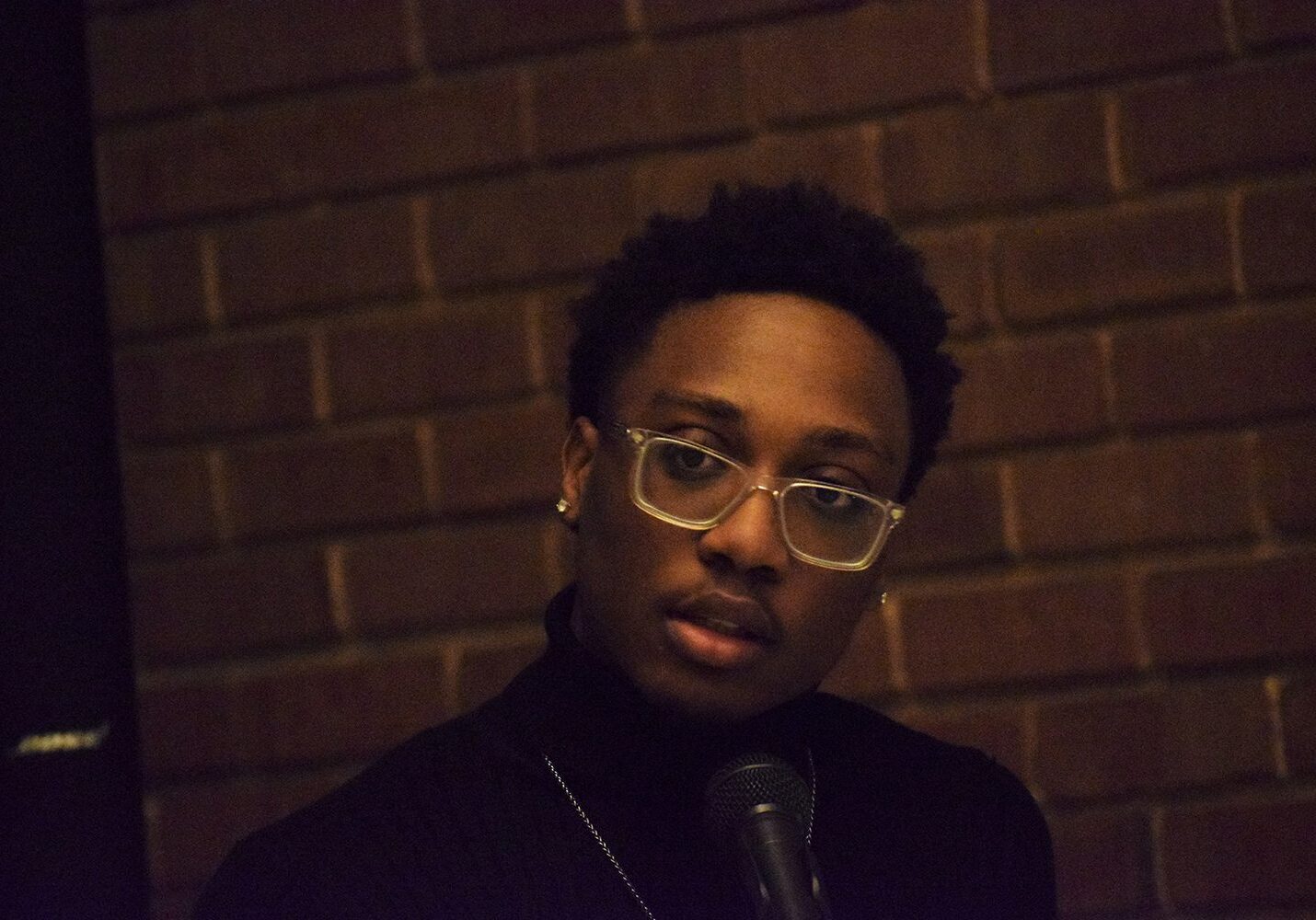 Individual addressing audience with microphone