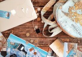 Backpack and travel maps with coins