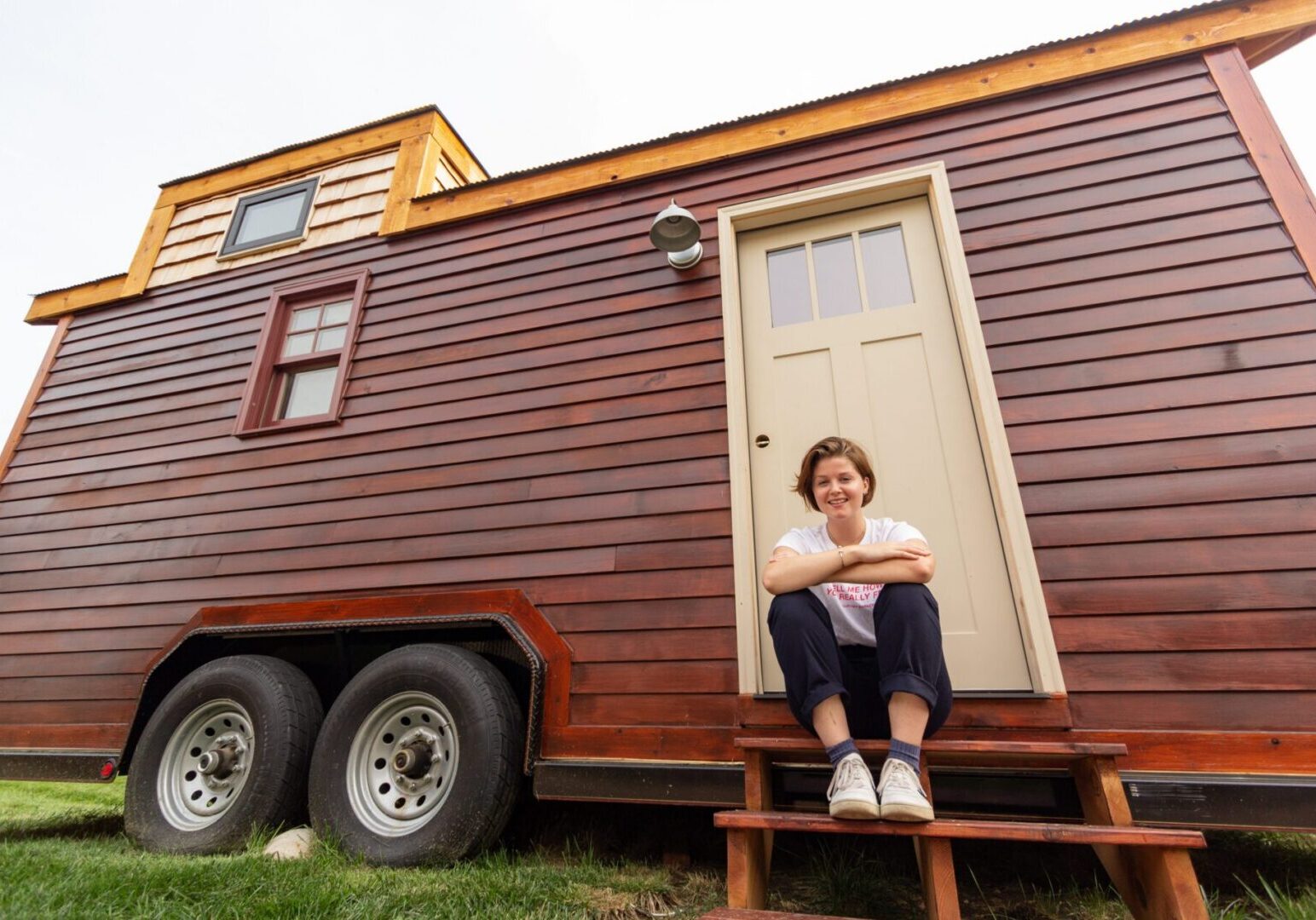 Wooden tiny home exterior with person seated