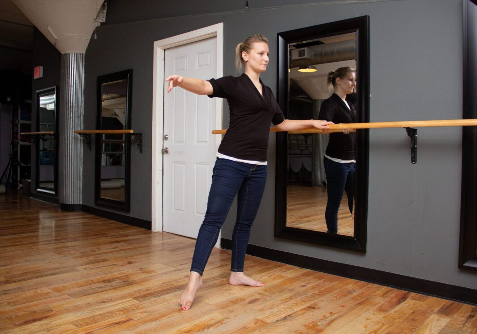 Dancer balancing at barre in dance studio