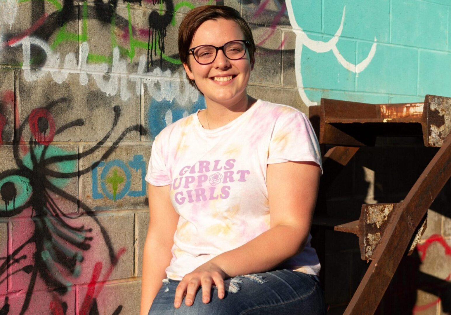 Person sitting on outdoor stairs, happy
