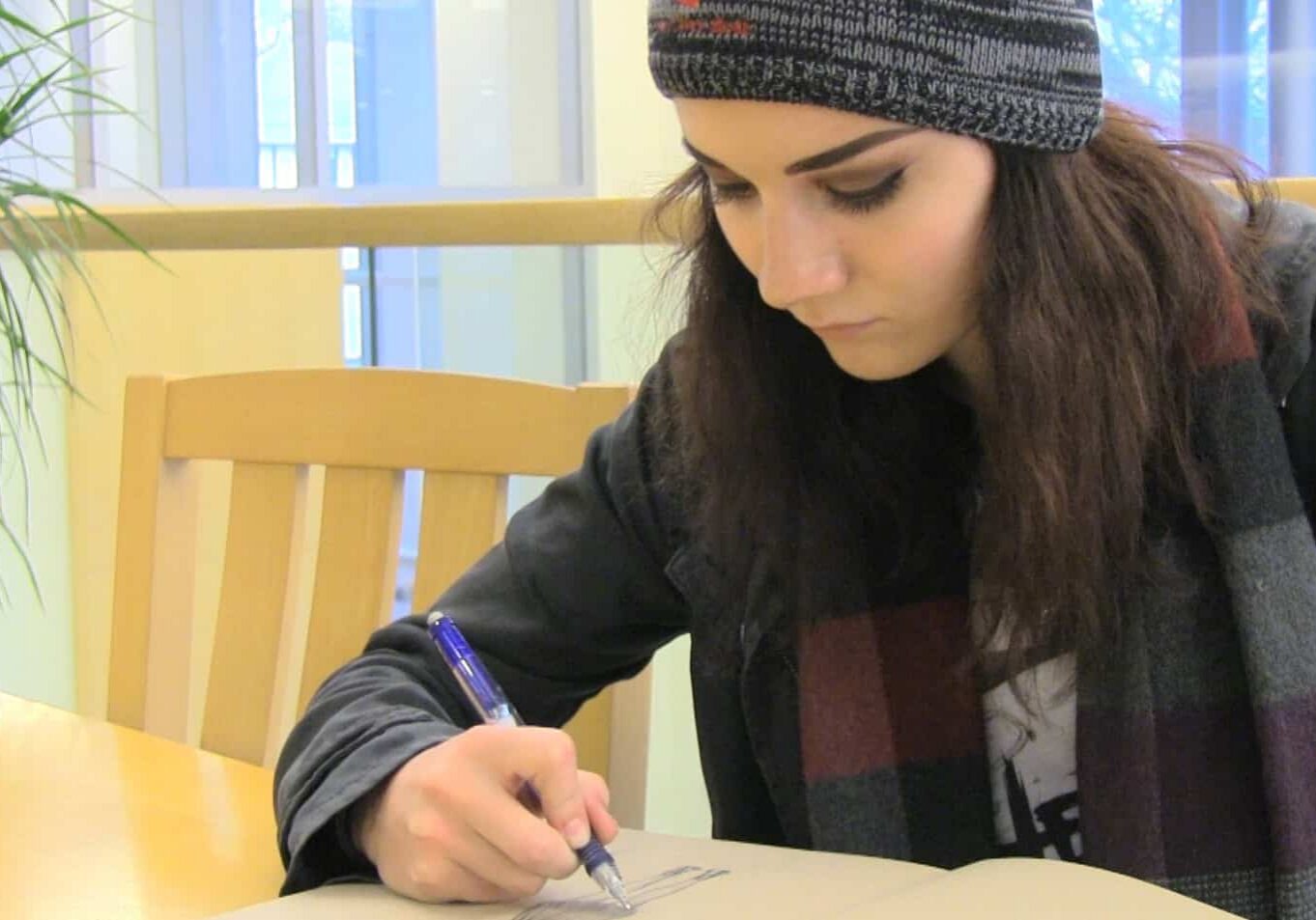 Individual taking notes indoors