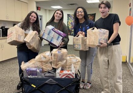 Four people with a wagon of groceries