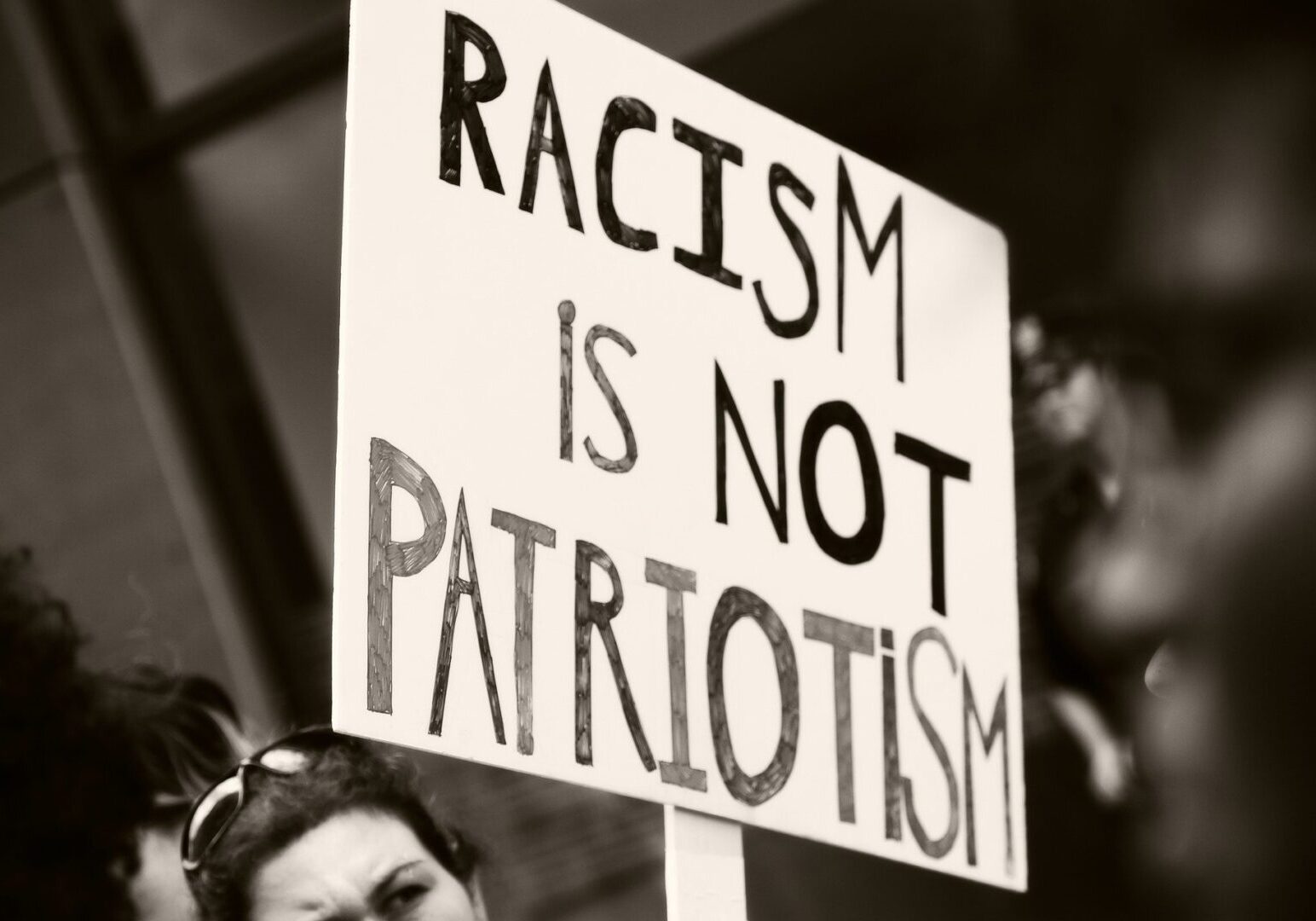 Sign reads: Racism is not patriotism
