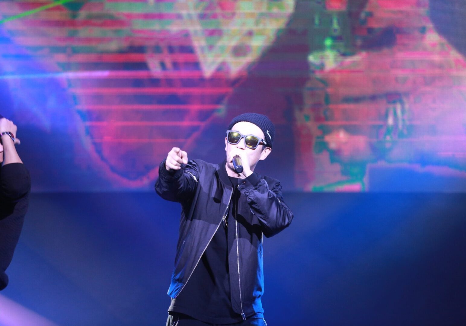 Artist in sunglasses pointing at audience