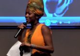 Speaker presenting on stage with microphone
