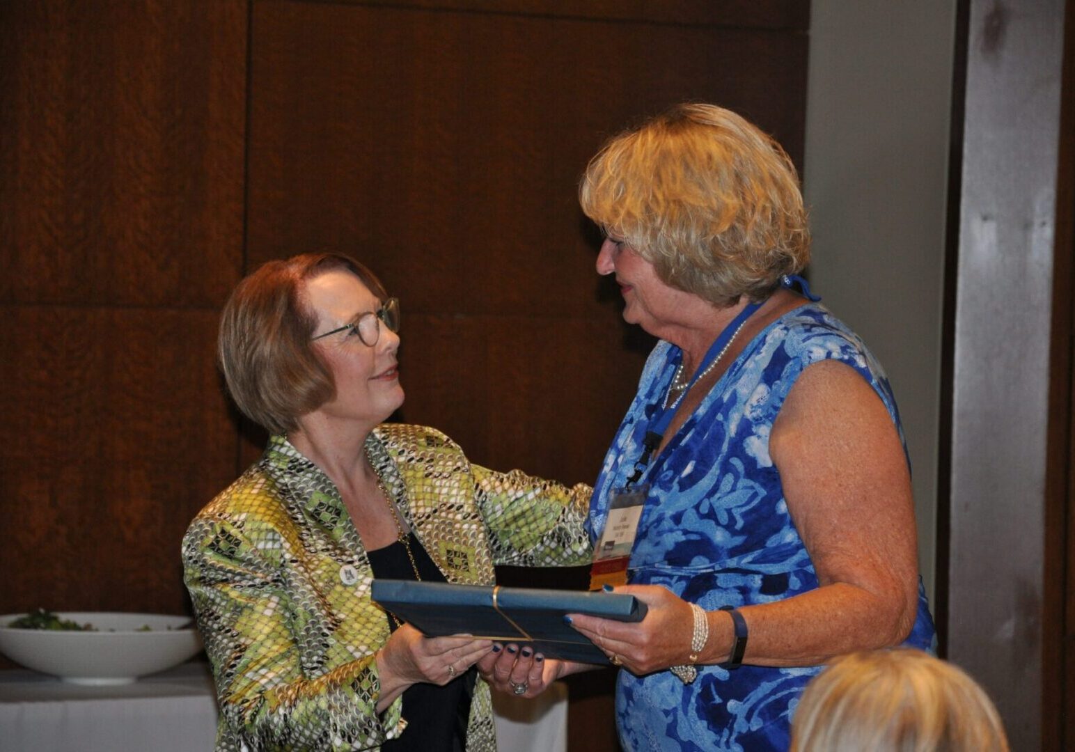 Two women exchanging an award