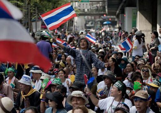 Crowd waving flags at outdoor rally