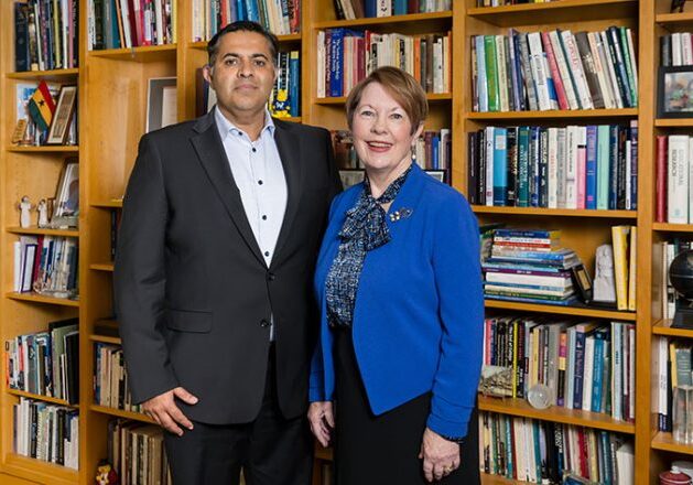 Colleagues posing by a book collection
